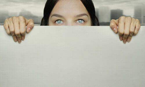 Frau guckt über einer Wand hervor