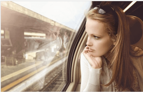 Frau schaut aus dem Zugfenster