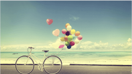 Fahrrad mit Luftballons am Strand