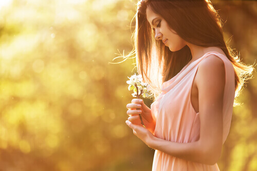 Frau betrachtet Blume