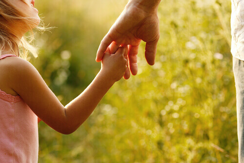 Maedchen greift nach Hand vom Vater