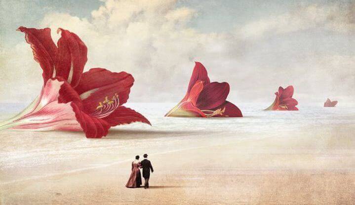 Paar-geht-am-Strand-mit-Riesenblumen-spazieren