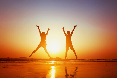 glueckliches-Paar-springt-am-Strand