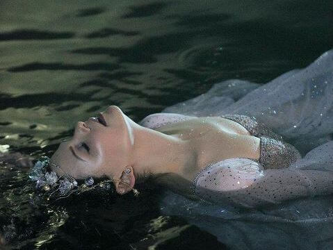 Frau liegt im Wasser