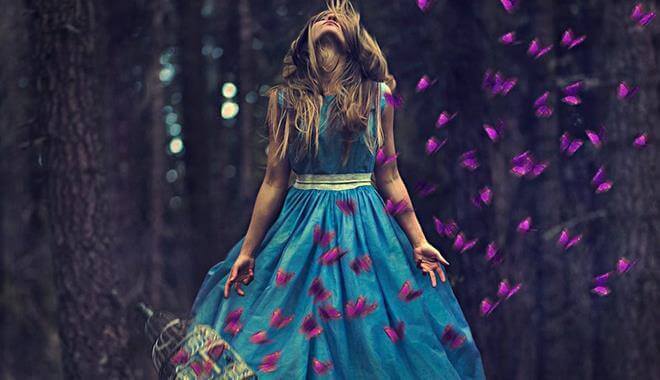 Frau im Wald mit lila Schmetterlingen
