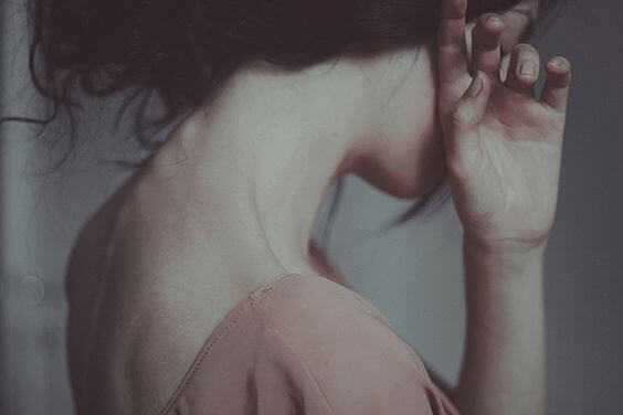 Frau verdeckt Gesicht, weil sie das Gespräch fürchtet