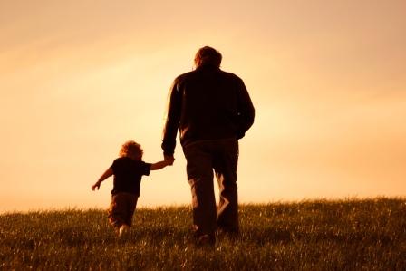 Opa läuft mit seinem Enkel über ein Feld