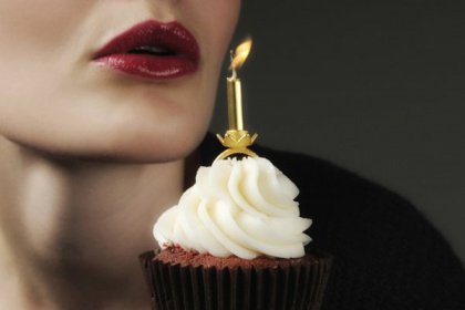 Frau pustet Kerze aus