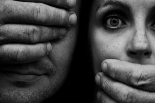 Dem Mann werden die Augen verdeckt, der Frau der Mund zugehalten