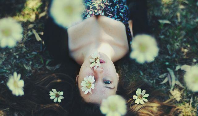 Junge Frau umgeben von Blumen