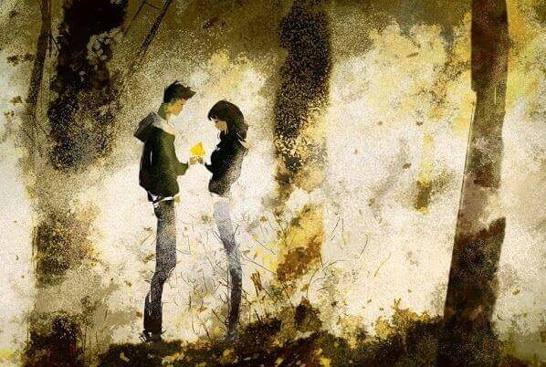 Paar steht im Wald und schaut auf ein Geschenk, das übergeben wird.