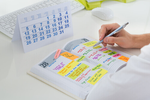 Eine Person trägt ihre Termine in einem Kalender ein. 