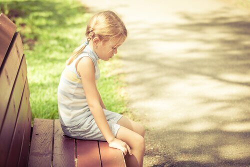 Trauriges Mädchen auf einer Parkbank