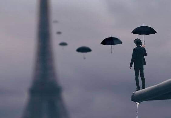 Mann mit Schirmen vor dem Eiffelturm