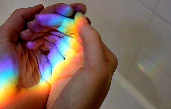 Prisma wirft Regenbogenfarben in die hohle Hand