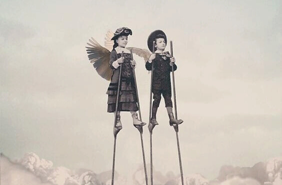 Kinder mit Flügeln auf dem Rücken gehen auf Stelzen