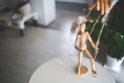 Eine Puppe, die durch eine Hand manipuliert wird