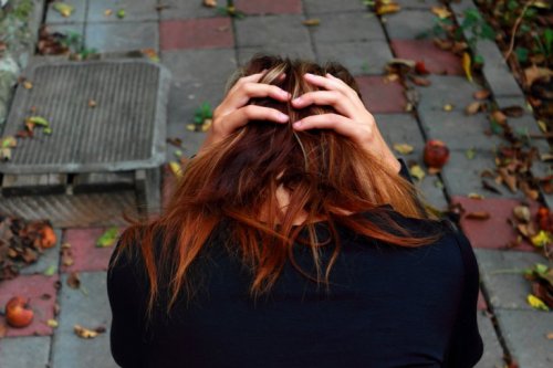 Frau, die ihren Kopf in den Händen hält