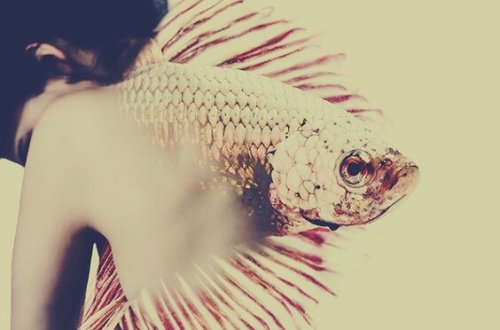 Fisch erwächst aus dem Rücken einer Frau