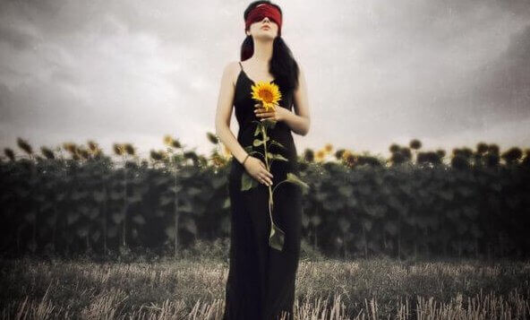 Frau mit Augenbinde und Sonnenblume