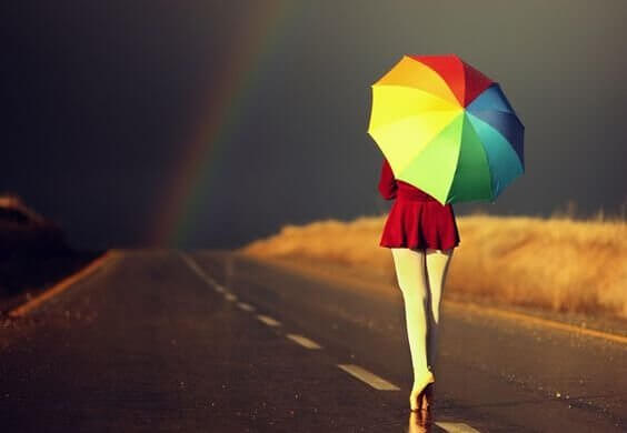 Mit buntem Regenschirm auf den dunklen Horizont zu