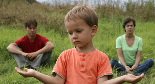 Kind mit Eltern im Hintergrund