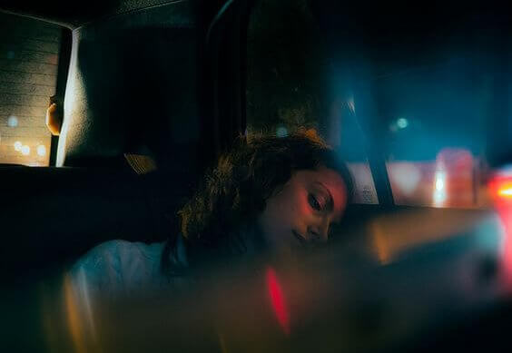 Frau sitzt bei Nacht im Taxi