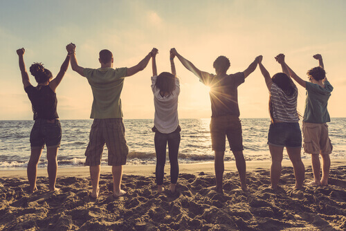 Freunde helfen uns, uns geschützt zu fühlen - Gruppe von Freunden am Strand