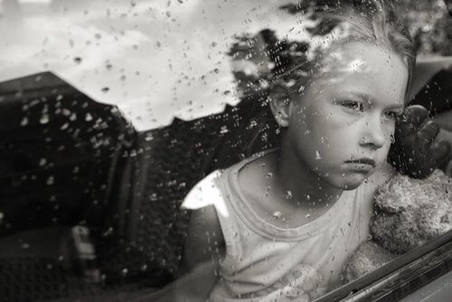 Trauriges Mädchen schaut aus dem Fenster