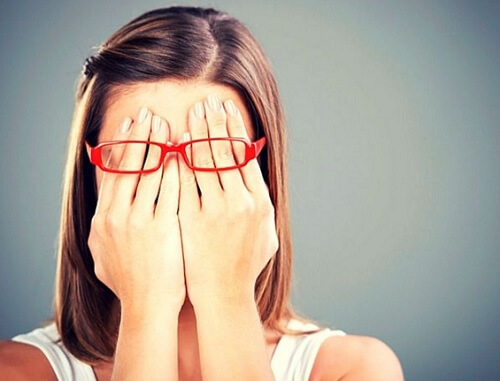 Frau, die ihr Gesicht mit ihren Händen verdeckt