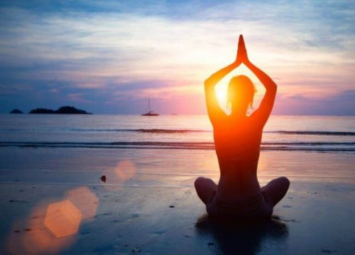 Frau praktiziert Yoga am Strand