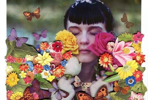 Mädchen mit geschlossenen Augen ist umgeben von Blumen