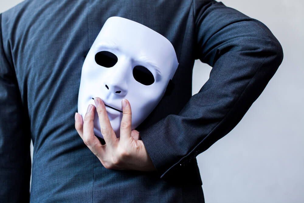 Mann hält Maske hinter dem Rücken
