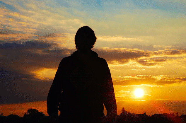 Mann betrachtet untergehende Sonne