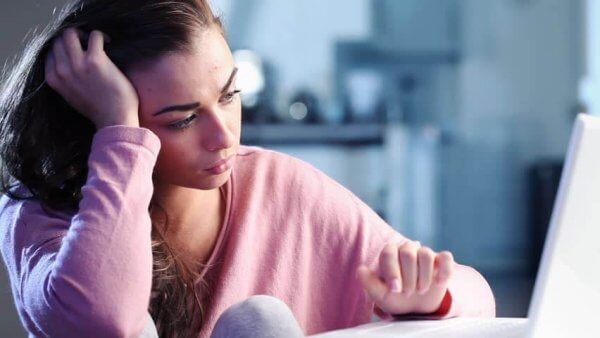 Trauriger Teenager sitzt vor Computer