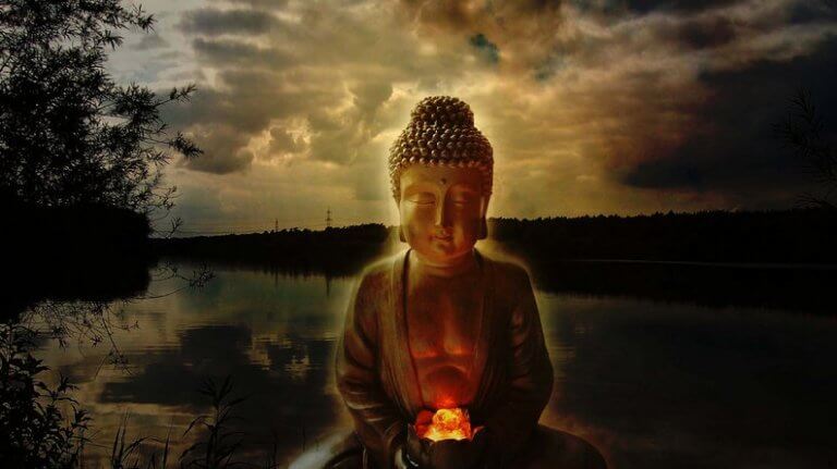 Die Statue eines Buddhas vor Abendstimmung am Fluss.