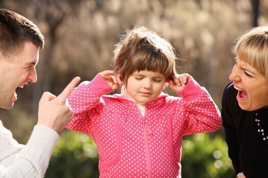 Kind hält sich die Ohren zu und hört gar nicht, was seine Eltern sagen - Kindererziehung ohne Schreie ist die bessere Alternative.