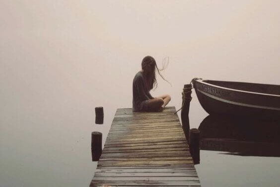 Einsame Frau auf einem Bootssteg