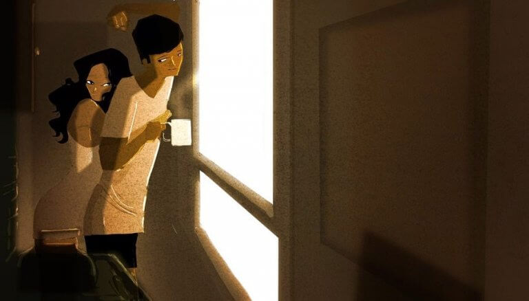 Paar umarmt sich am Fenster