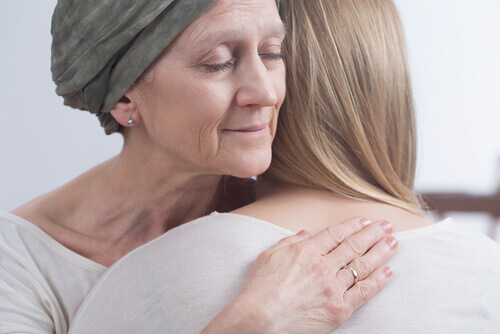 Tochter umarmt krebskranke Mutter. Krebspatienten brauchen Hilfe.