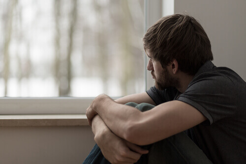 Trauriger Mann sitzt am Fenster