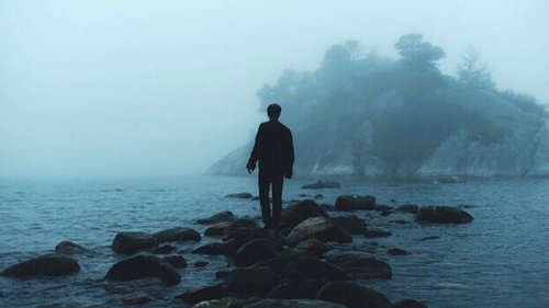 Mann, der auf Steinen das Meer überquert