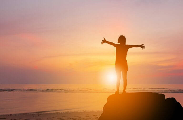 Frau bei Sonnenaufgang am Meer