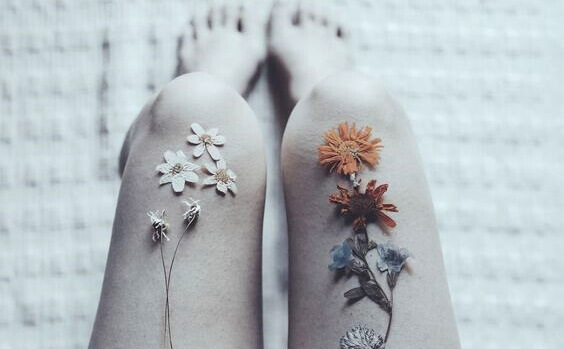 Beine mit Blumen auf den Oberschenkeln