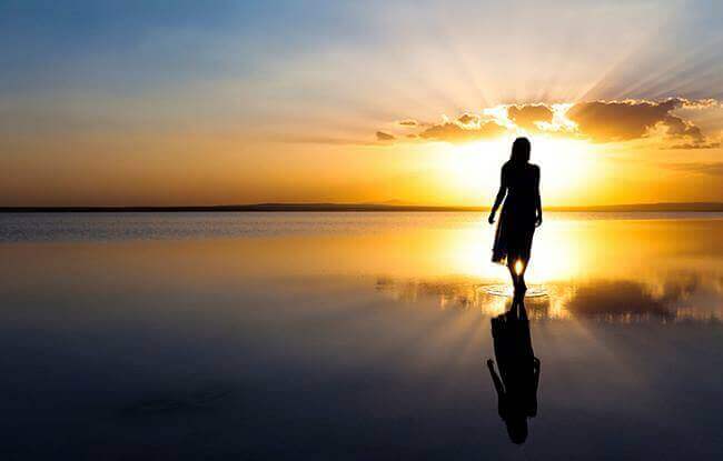 Frau bei Sonnenaufgang am Strand