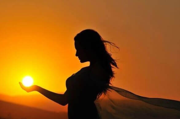 Frau hält Sonne in der Hand
