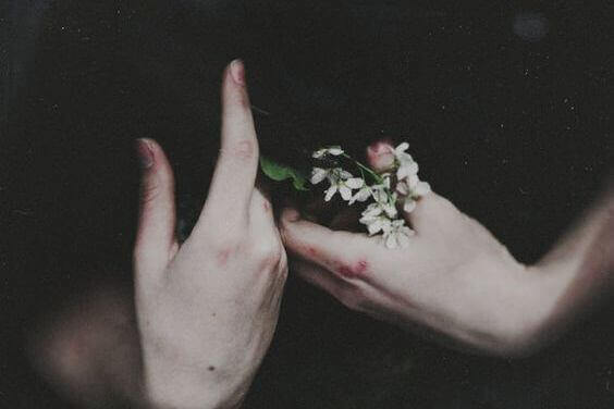 Hände, die Blumen halten