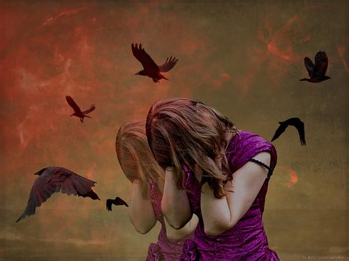 Verstörte Frau umgeben von Raben