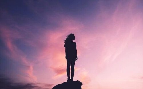 Frau, die auf den lila Himmel blickt