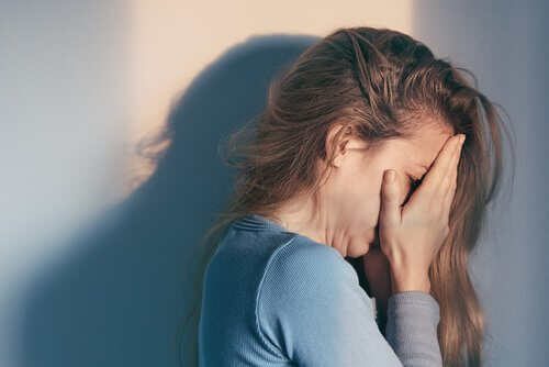 Frau, die ihre Hände vor ihrem Gesicht hält